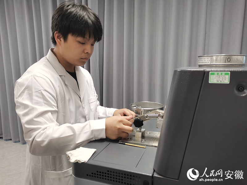 实验员对镁块进行检测。人民网记者 胡雨松摄